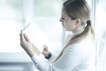 Young adult girl with book learning, reading, business