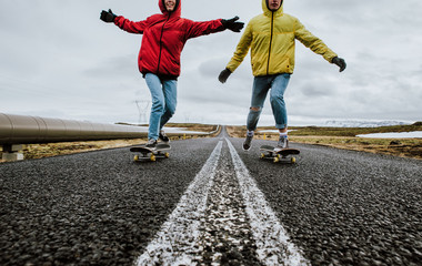 Couple of teenagers having fun skating and making downhill in Iceland