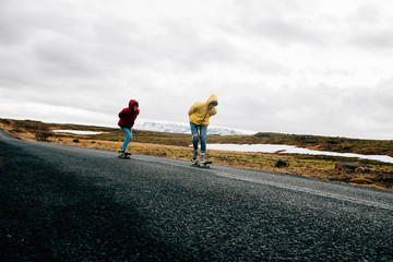 Fototapeta premium Couple of teenagers having fun skating and making downhill in Iceland