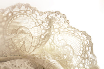 Background texture of soft fabric, pattern. White lace. Close-up, selective focus, side view, copy space.