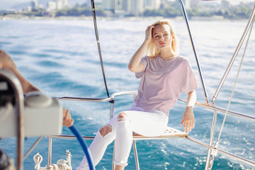 Holiday on a sailing yacht. Amazing blonde girl travelling on yacht in Carribean sea