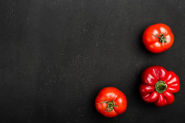 Cooking concept - red pappers and tomatos on stone table. Set of healthy food products are sources of vitamins and minerals. Top view