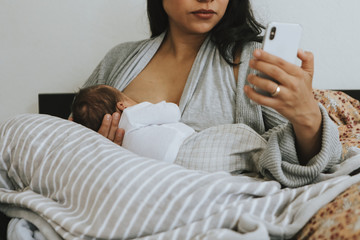 Breastfeeding mother using a smartphone