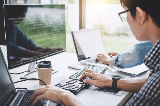 Programmers cooperating at Developing programming and website working in a software develop company office, writing codes and typing data code
