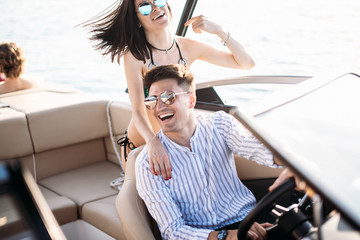 Newly married caucasian couple driving sailboat, enjoying water summer adventure, spending...