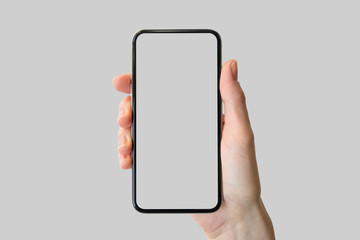 Hand holding bezel-free / frameless modern smartphone in front of neutral background