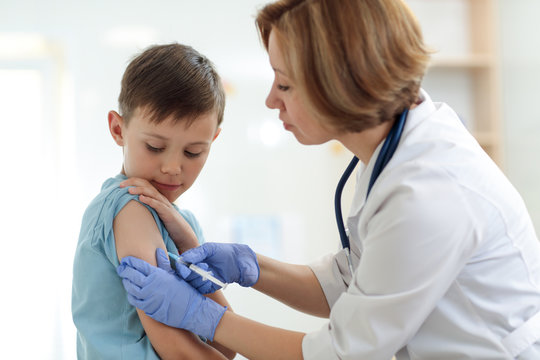 Brave child boy receiving injection or vaccine with a smile