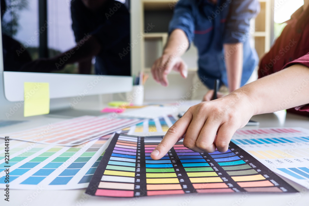 Poster Two colleagues creative graphic designer working on color selection and drawing on graphics tablet at workplace