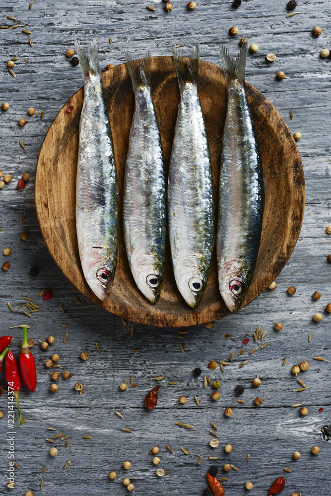 Poster raw sardines on a rustic wooden table