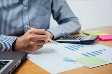 Business man or accountant working Financial investment on calculator with calculate Analyze business and market growth on financial document data graph