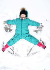 Fototapeta na wymiar Cute girl plays in snowy weather outdoor. 
