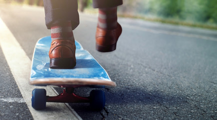 Work Life Balance Concept. Low Section of Businessman Balancing his Body on Skateboard in Park