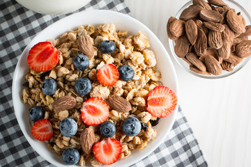Healthy breakfast concept with oat flakes and fresh berries on rustic background. Food made of granola and muesli. Healthy banana smoothie with blackberries, honey and milk.
