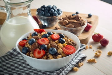 Healthy breakfast concept with oat flakes and fresh berries on rustic background. Food made of granola and muesli. Healthy banana smoothie with blackberries, honey and milk.