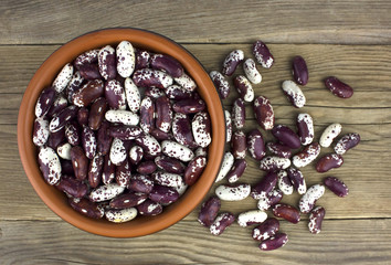 Haricot beans in bowl on wooden background