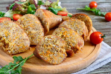 Tasty stuffed chicken legs with salad of fresh vegetables on a wooden background. Rolls with...