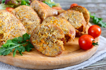 Tasty stuffed chicken legs with salad of fresh vegetables on a wooden background. Rolls with chicken and vegetables.