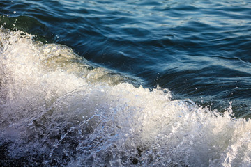 Waves at sea in the rays of sunset