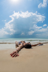 Brunette tanned girl in swimwear enjoying the beach