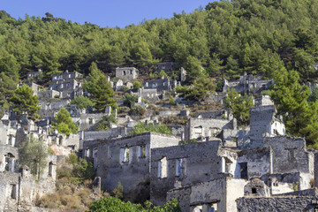 Fototapeta na wymiar Masonry rocky houses of an old village in Turkey founded by old Greeks with background of forest
