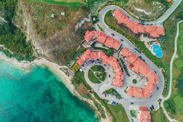 Obraz premium Aerial view of swimming pool and green garden in the beautiful resort, aerial top view