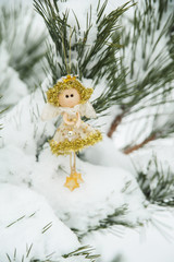 Decorative toy angel on pine.
