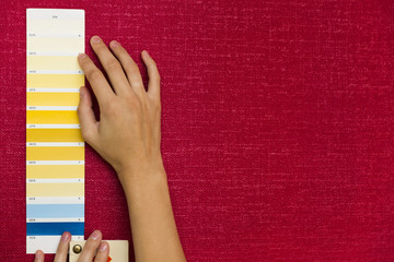 Home improvement. Beautiful women choosing a color from color palette. Renovating a room.