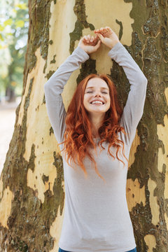 Happy carefree redhead woman outdoors in a park