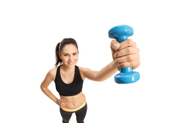 Fototapeta premium Young female in sportswear holding a dumbbell