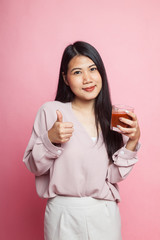 Young Asian woman thumbs up with tomato juice.