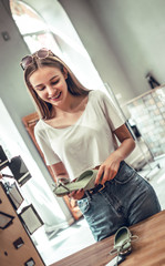 Young woman chooses shoes in shop