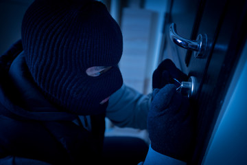 burglar breaking the lock of a door