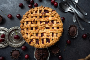 American homemade cherry pie on the table and muffins.