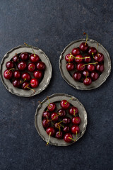 fresh cherry in vintage silver plate over dark grunge background.