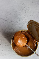 Dulce de leche in a metal tin on a natural stone background.