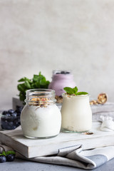 Jars with healthy yogurt with fresh blueberries, granola and mint. Tasty parfaits