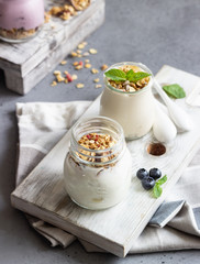 Jars with healthy yogurt with fresh blueberries, granola and mint. Tasty parfaits