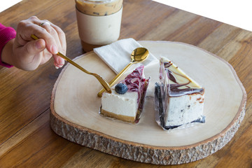 Woman use spoon to scoop blueberry cake from chopping block in cafe