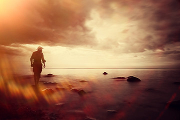 Fototapeta premium landscape sunset on the sea, man on the lake shore at sunset, beautiful place nature, water and seashore, concept of waiting for loneliness