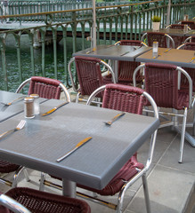 Empty cosy french street cafe or brasserie located on small river with served tables ready for visitors
