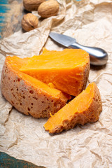 Pieces of native French aged cheese Mimolette, produced in Lille with greyish curst made by special cheese mites