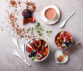 Granola with figs,yogurt,nuts,berries,Goji berries and honey and a Cup of coffee with milk. Healthy Breakfast.  top view.selective focus.