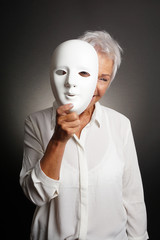 happy smiling playful mature woman peeking from behind mask