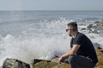 young man walking on the beach on a sunny day