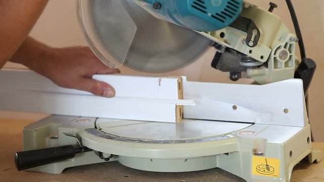 Joiner cut a wooden plank with circular saw.