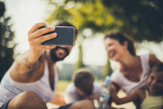 Close up image of father taking self portrait of family.