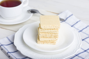 Waffle bars on white plate with cup of tea