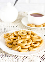 Cup of tea with bagels cookies on rustic serving table