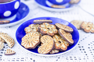 Tea time on rustic table with chocolate poppy seed cookies
