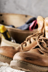 Yellow leather used work boots and tool belt on wooden background closeup. Place for text